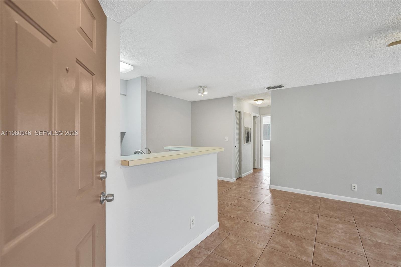 This interior view shows an entryway leading to a living area with tiled floors — 2846 S University Dr # 4102, Davie FL 33328, DAVIE, FL