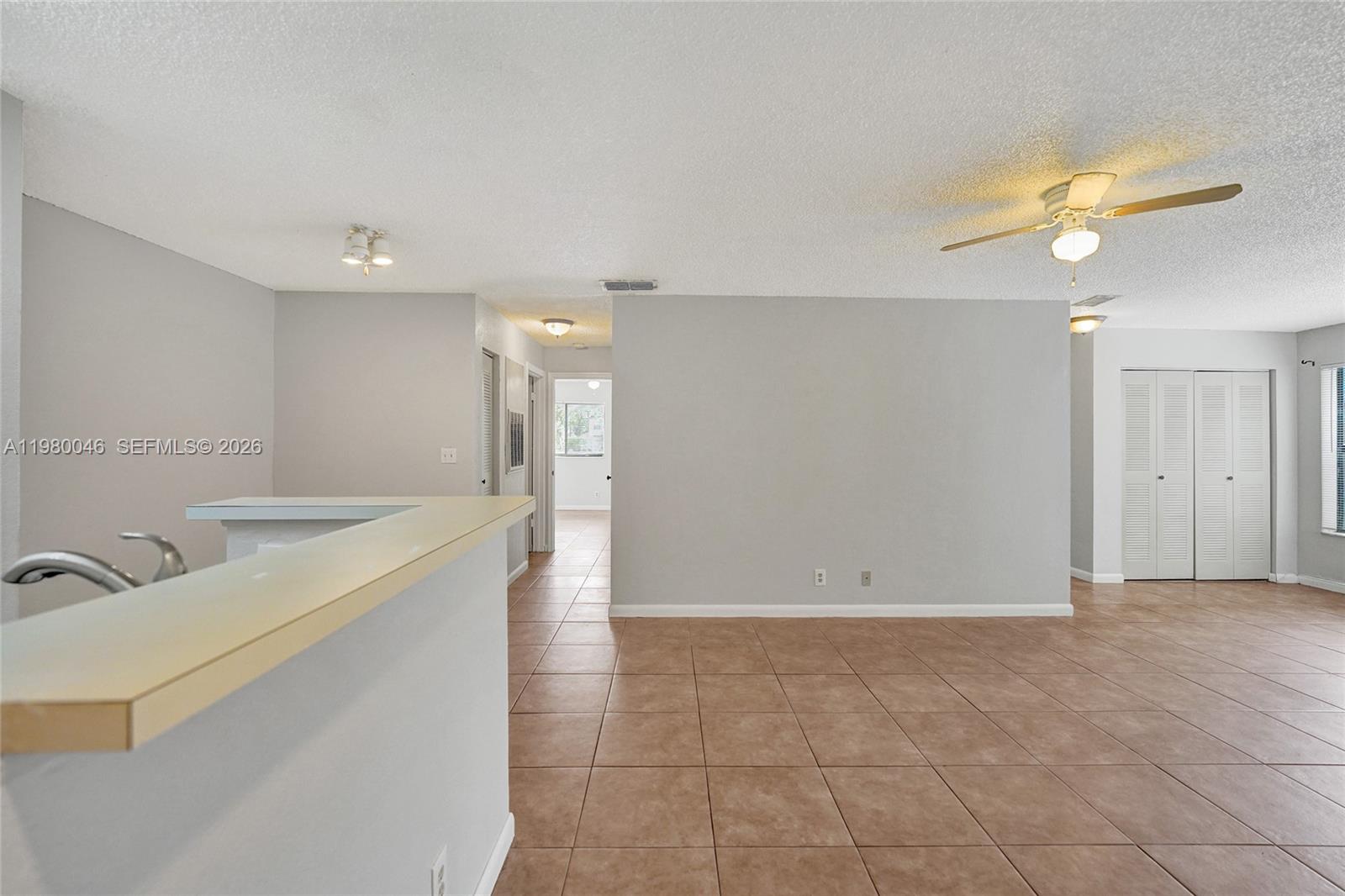 An open-concept living area features light gray walls, brown tile flooring, and a ceiling fan — 2846 S University Dr # 4102, Davie FL 33328, DAVIE, FL