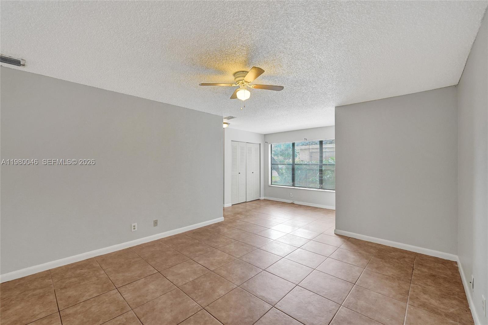A room with light gray walls, brown tile flooring, a ceiling fan, and a window — 2846 S University Dr # 4102, Davie FL 33328, DAVIE, FL