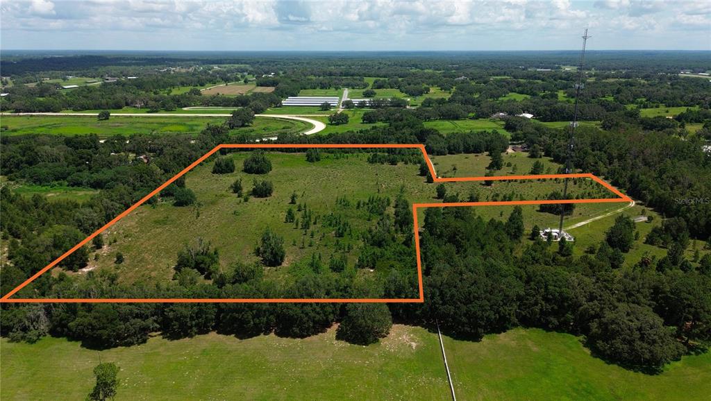 An aerial view shows a large, grassy, partially wooded plot of land outlined in orange — SW 41ST PLACE, OCALA, FL