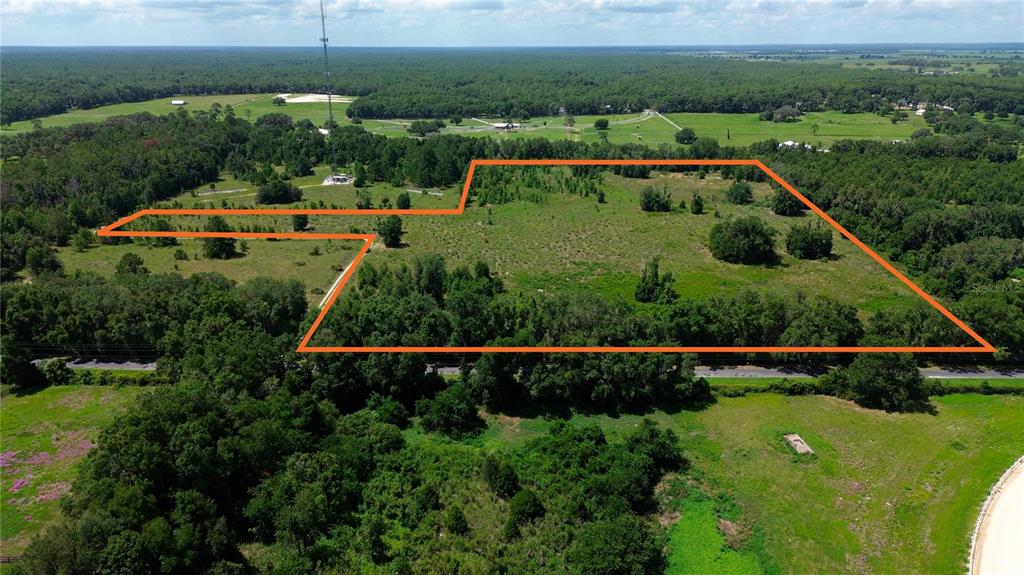 An aerial view shows a large, grassy, partially wooded plot of land outlined in orange — SW 41ST PLACE, OCALA, FL