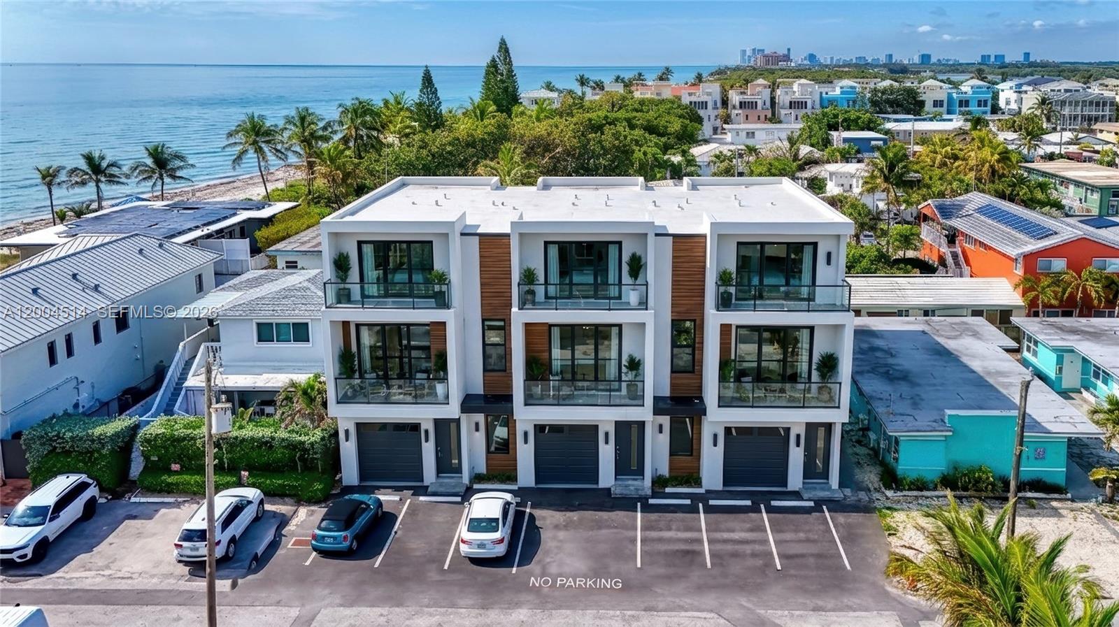 An aerial view shows a modern three-story residential building with balconies and a parking lot — 318 Walnut St, Hollywood FL 33019, HOLLYWOOD, FL