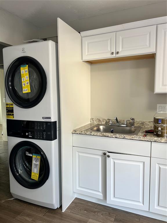 A laundry area features a stacked washer-dryer unit next to a sink with white cabinets — 901 COLYER STREET, ORLANDO, FL