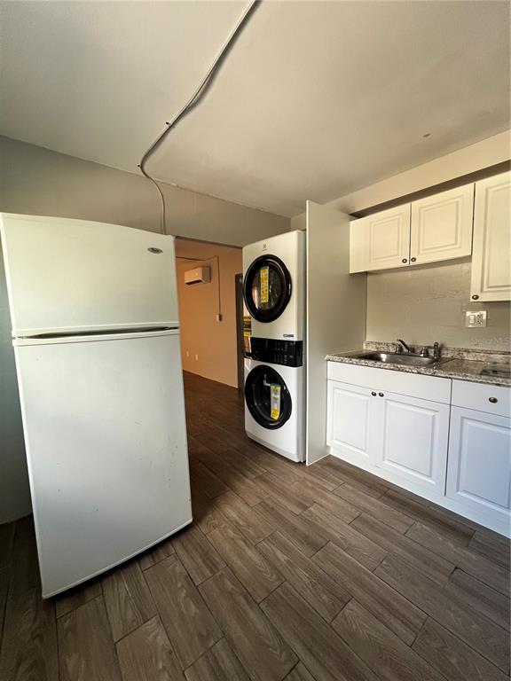 A kitchen area features a white refrigerator, stacked laundry unit, and white cabinetry — 901 COLYER STREET, ORLANDO, FL
