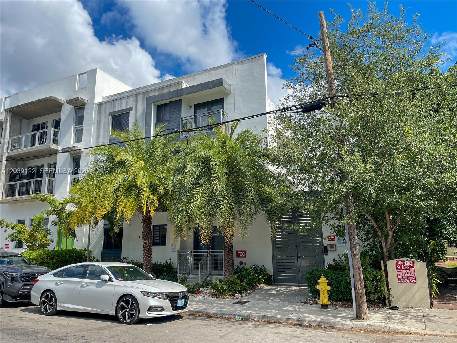 A white multi-story residential building features palm trees, a parked car, and a fire hydrant — 761 NW 1st St, Miami FL 33128, MIAMI, FL