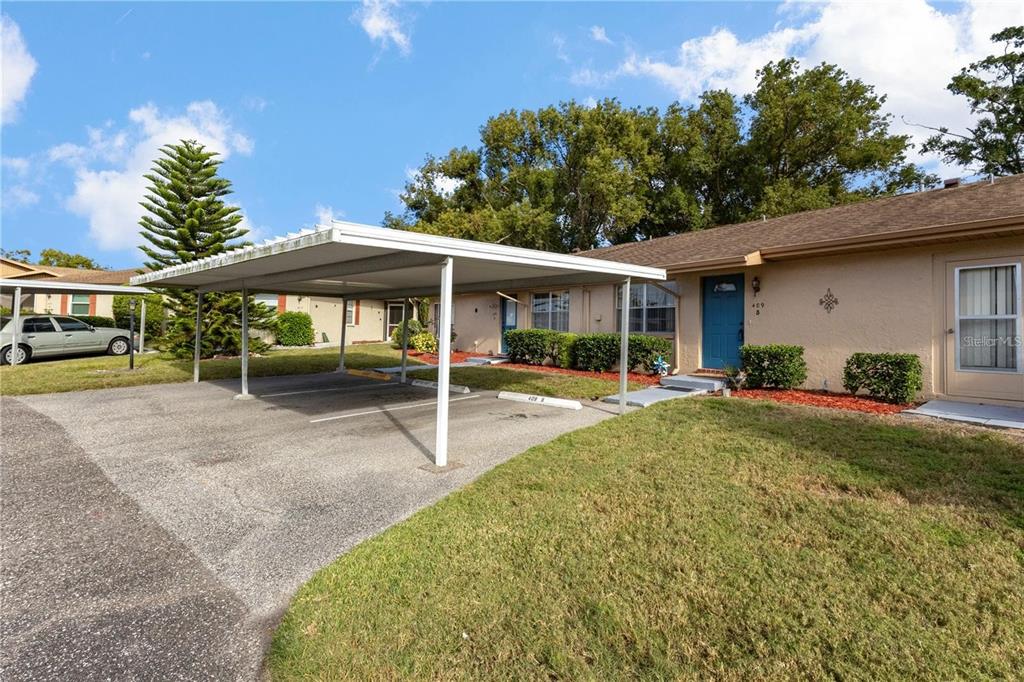 A single-story building with a covered carport and a blue front door — 409 FELTHAM TRAIL UNIT B, SUN CITY CENTER, FL