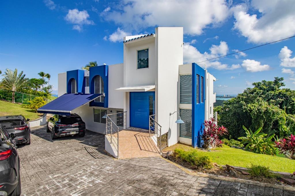 A modern two-story house with blue accents, a paved driveway, and a blue front door — 1 PR 968 KM 2, RIO GRANDE, PR