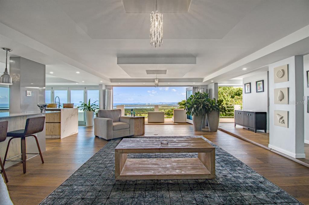 A modern open-concept living room features a wooden coffee table, area rug, and ocean views — 1 PR 968 KM 2, RIO GRANDE, PR