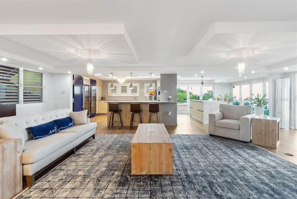 An open-concept living room and kitchen featuring a large area rug and wooden coffee table — 1 PR 968 KM 2, RIO GRANDE, PR