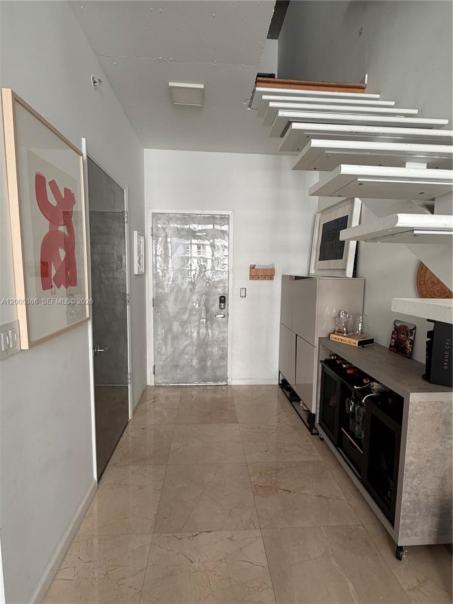 A modern entryway features marble floors, a floating staircase, and a bar cabinet — 690 SW 1st Ct # 2524, Miami FL 33130, MIAMI, FL