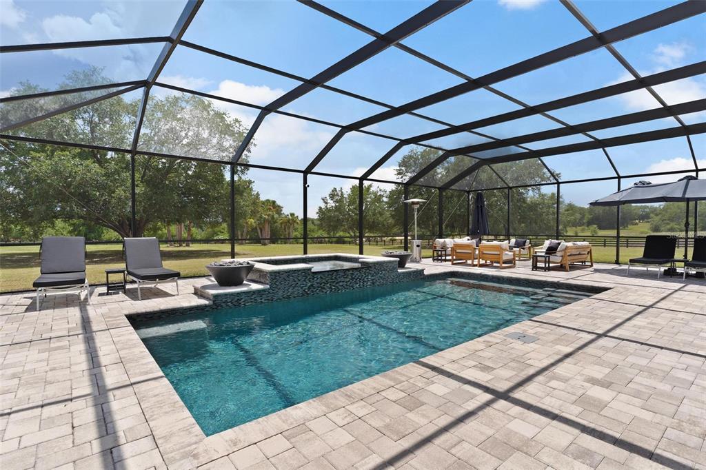 A rectangular swimming pool and spa are enclosed within a screened-in patio area — 5509 NANTAHALA LANE, LADY LAKE, FL
