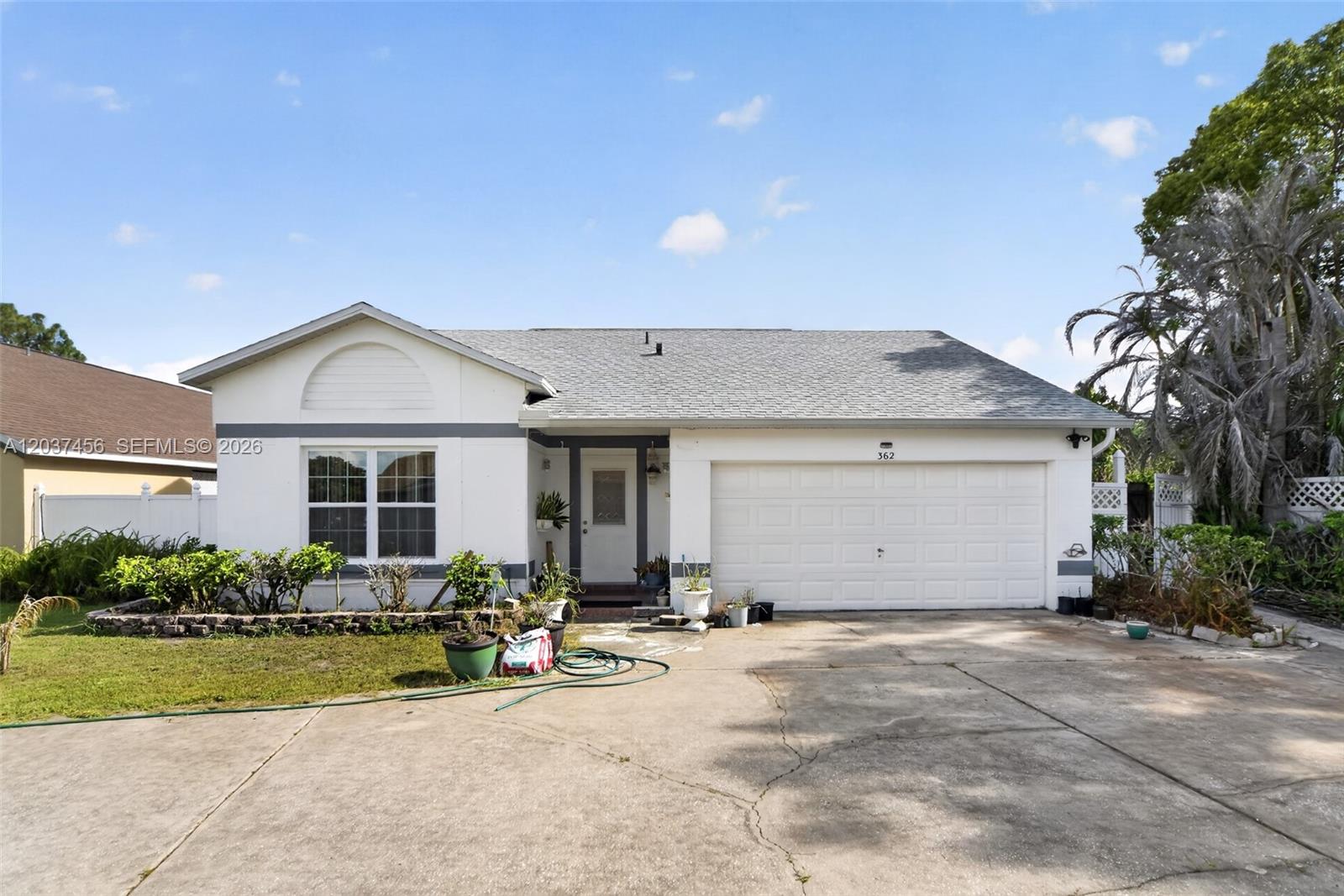 A single-story house with a white exterior, a two-car garage, and a concrete driveway — 362 WHITE MARSH CIRCLE, Orlando FL 32824, ORLANDO, FL