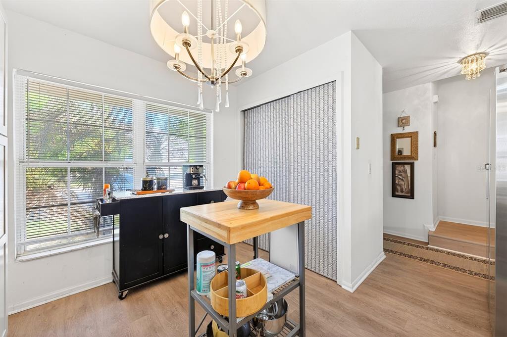 A kitchen area features a wooden island, a black rolling cart, and a patterned closet door — 299 WOODGREEN LANE, WINTER SPRINGS, FL