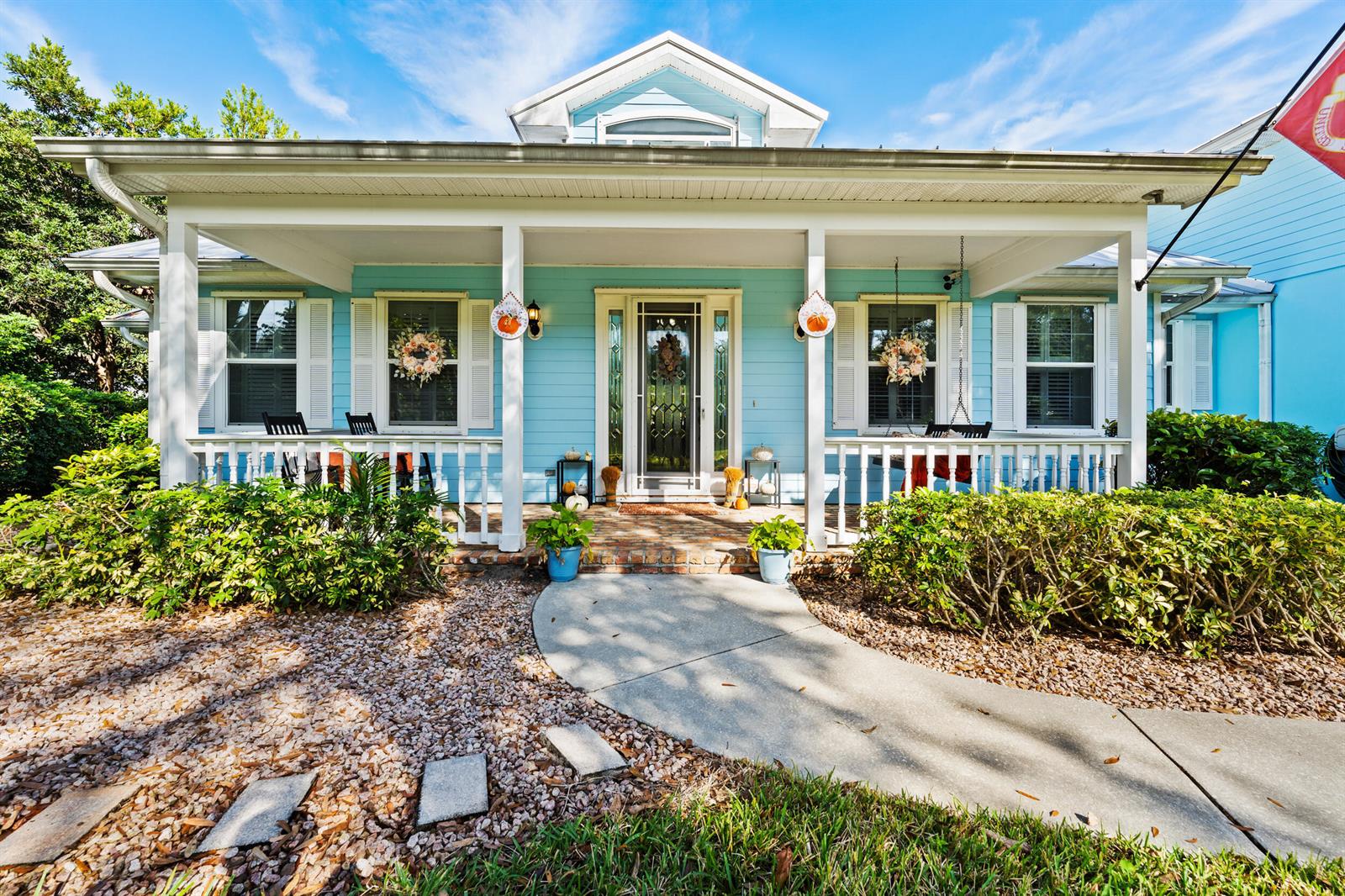 A light blue house features a covered front porch with white railings and a walkway — 619 Fischer Hammock Road, Sebastian FL 32958, SEBASTIAN, FL