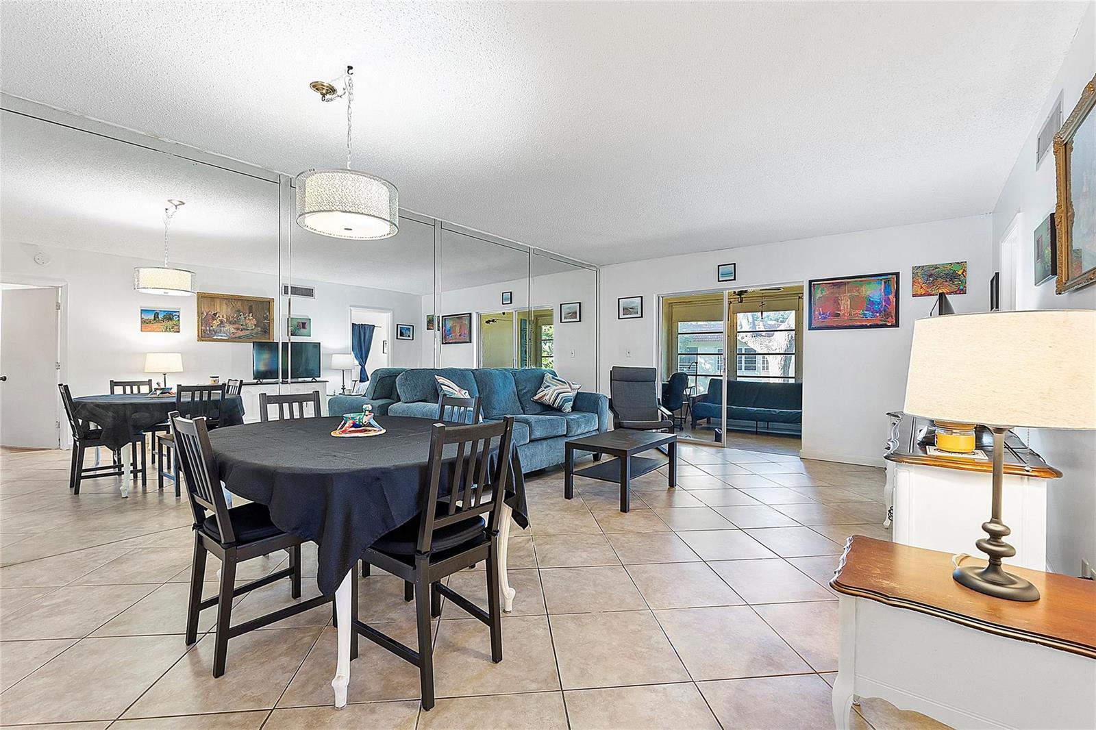 A living and dining area features tiled floors, a mirrored wall, and a blue sofa — 5621 SW 2nd Court # 201, Margate FL 33068, MARGATE, FL