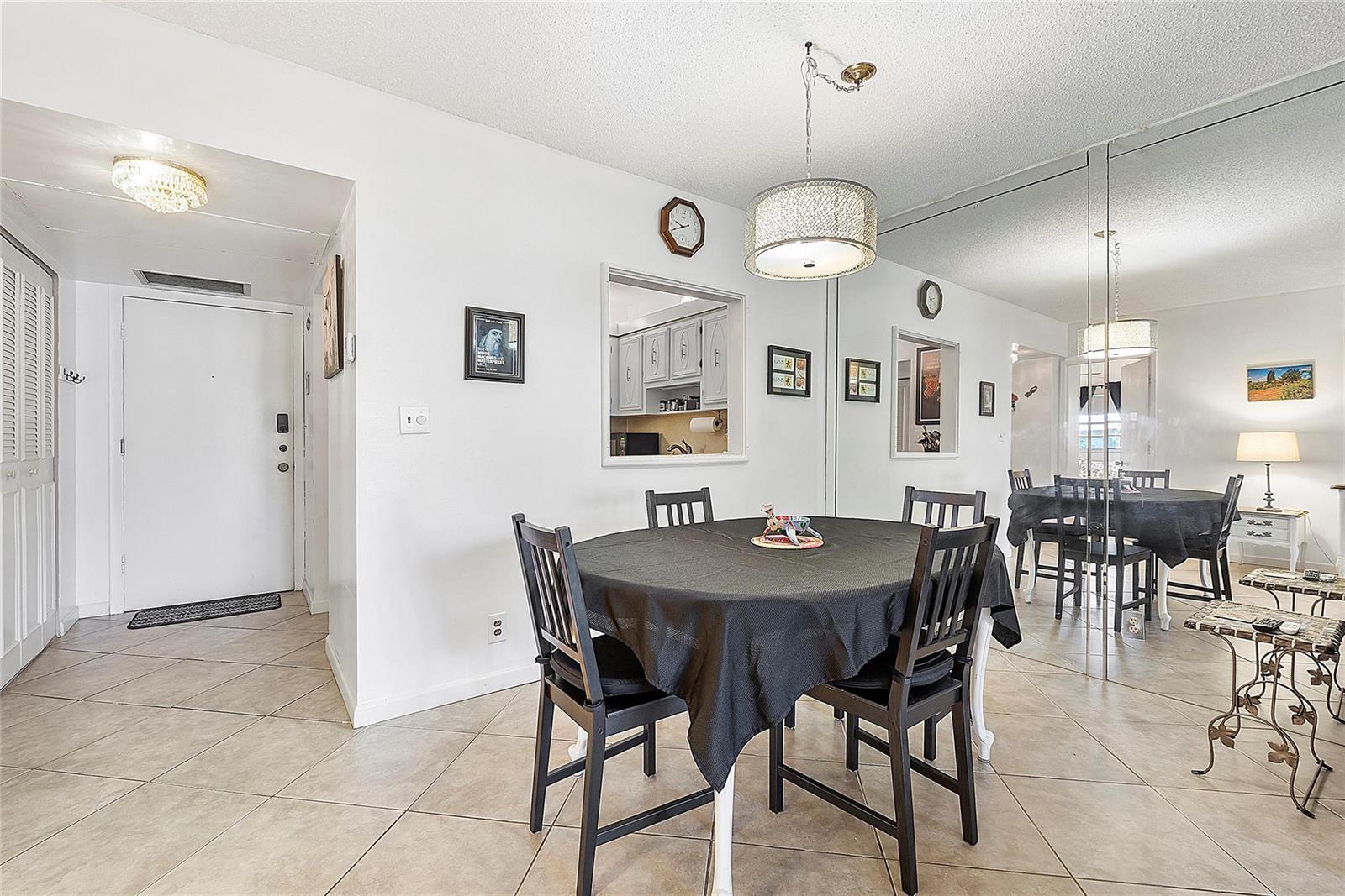 A dining area features a round table with black chairs, tile flooring, and mirrored walls — 5621 SW 2nd Court # 201, Margate FL 33068, MARGATE, FL