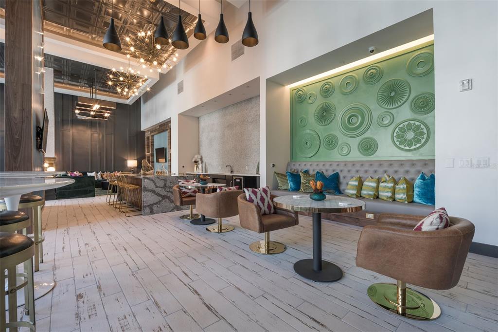 A modern lounge area features a green accent wall with circular medallions and swivel chairs — 733 MAIN LN LANE, ORLANDO, FL