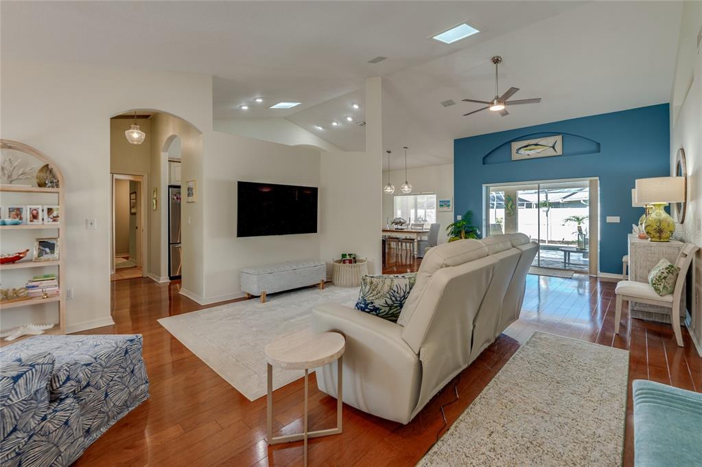 A living room features hardwood floors, a blue accent wall, and a mounted television — 30 EVANS DRIVE, PALM COAST, FL