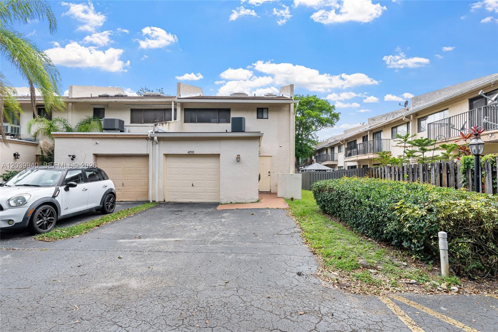 A two-story townhouse exterior features a beige stucco facade, two garage doors, and a driveway — 4293 N 76th Ave, Davie FL 33024, DAVIE, FL