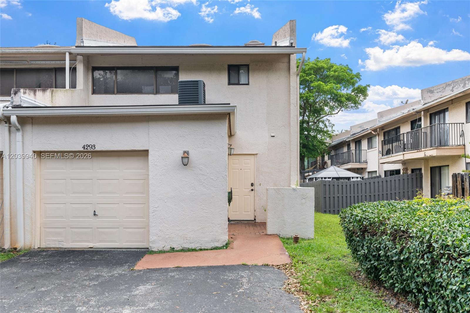 A two-story townhouse features a beige stucco exterior, a single-car garage, and a front entrance — 4293 N 76th Ave, Davie FL 33024, DAVIE, FL