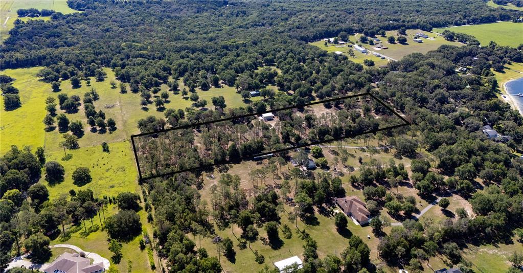 An aerial view shows a rectangular property boundary outlined over a wooded, rural landscape — 0 REED ROAD, DADE CITY, FL