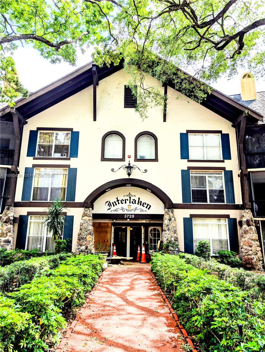 A three-story building with a stone-accented arched entrance and a brick walkway — 3720 Inverrary Dr # 1J, Lauderhill FL 33319, LAUDERHILL, FL