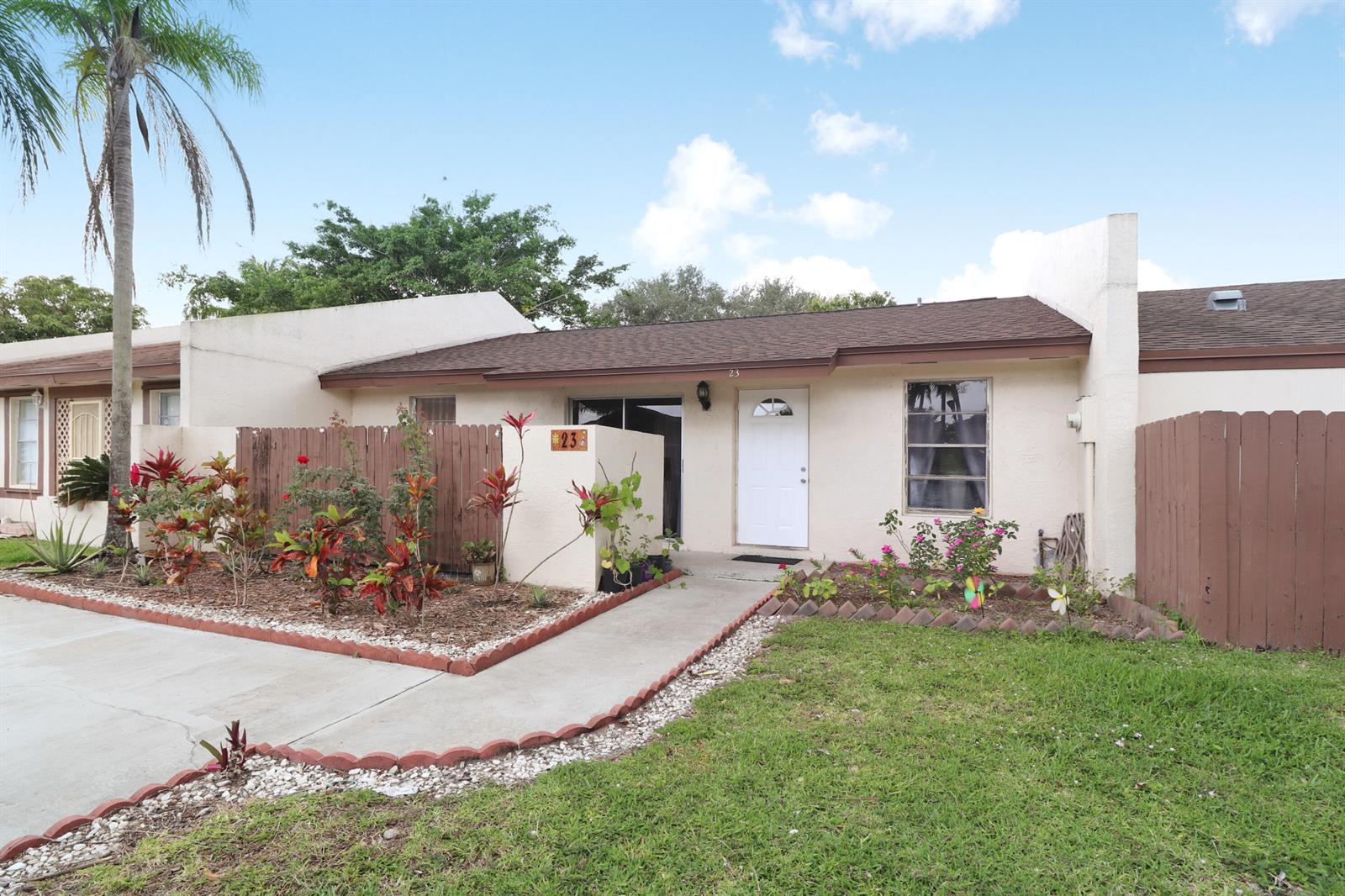 A single-story house with a white front door, a concrete walkway, and a small garden — 23 Chelsea Lane, Boynton Beach FL 33426, BOYNTON BEACH, FL