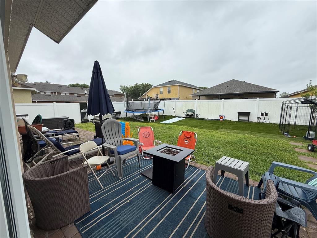 A living room features a grey sectional sofa, brown recliner, television, and dark wood flooring — 2268 VICTORIA FALLS DRIVE, ORLANDO, FL