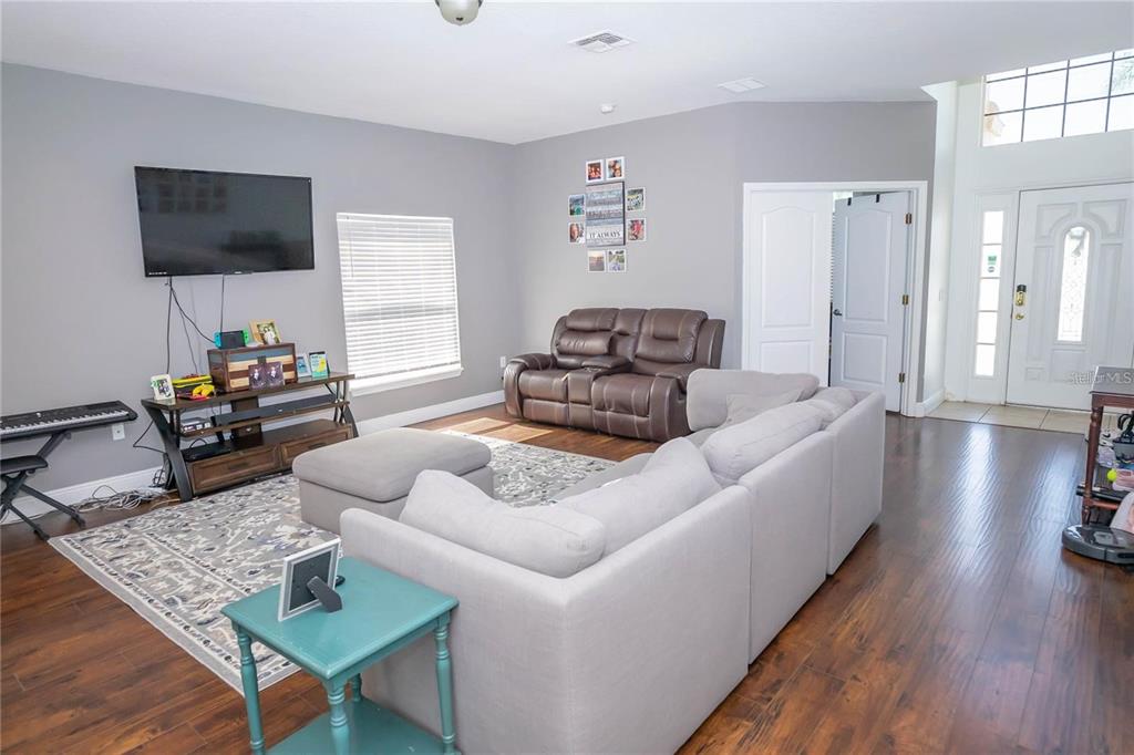 A kitchen features white cabinetry, stainless steel appliances, a tile backsplash, and light tile flooring — 2268 VICTORIA FALLS DRIVE, ORLANDO, FL