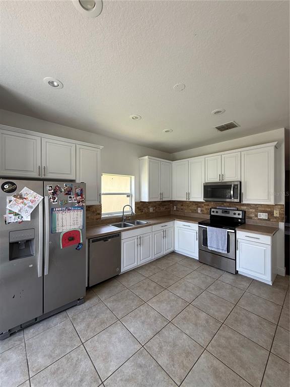 A bedroom features a bed, a patterned area rug, a ceiling fan, and two windows — 2268 VICTORIA FALLS DRIVE, ORLANDO, FL