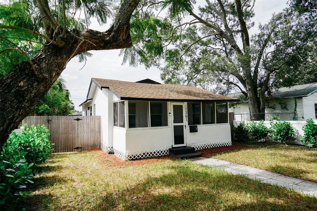 A small white house with a screened-in porch and a brown shingled roof — 1361 29TH STREET S, ST PETERSBURG, FL