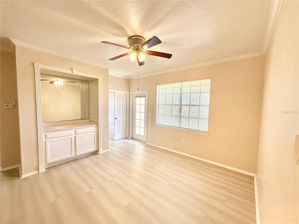 A room with light wood-look flooring, a ceiling fan, a window, and a built-in cabinet — 2528 ROBERT TRENT JONES DRIVE UNIT 1625, ORLANDO, FL