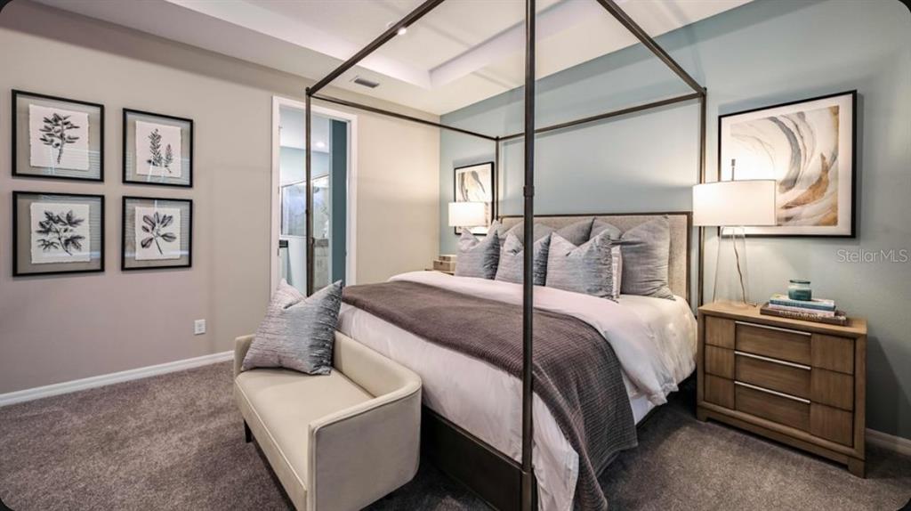 A bedroom features a four-poster bed, a light blue accent wall, and a beige bench — 7045 FOXBORO WAY, NOKOMIS, FL