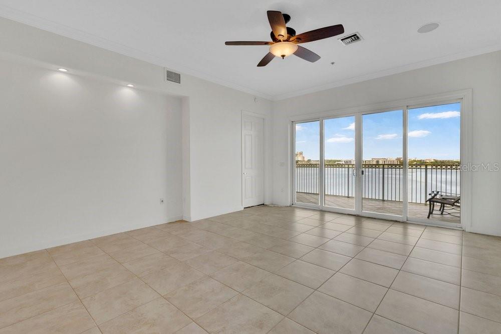 An empty room with light tile flooring, a ceiling fan, and sliding glass doors to a balcony — 8749 THE ESPLANADE UNIT 22, ORLANDO, FL