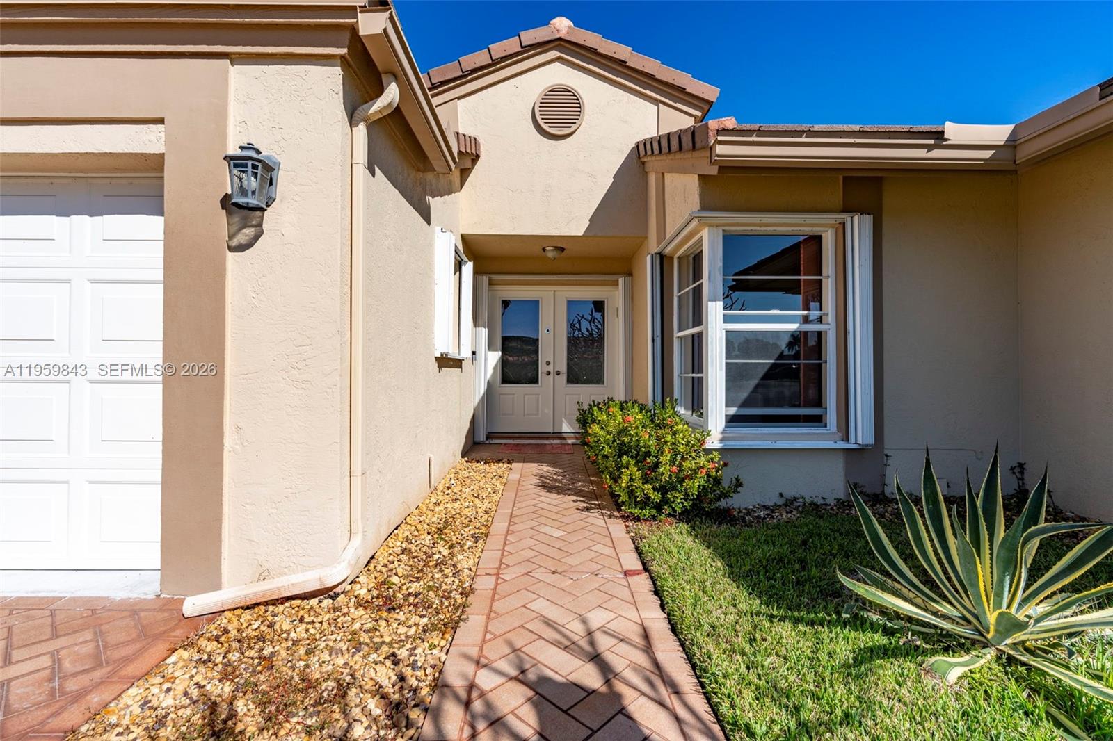 A beige house exterior features a brick walkway leading to double front entry doors — 4024 Summer Chase Ct, Lake Worth FL 33467, LAKE WORTH, FL