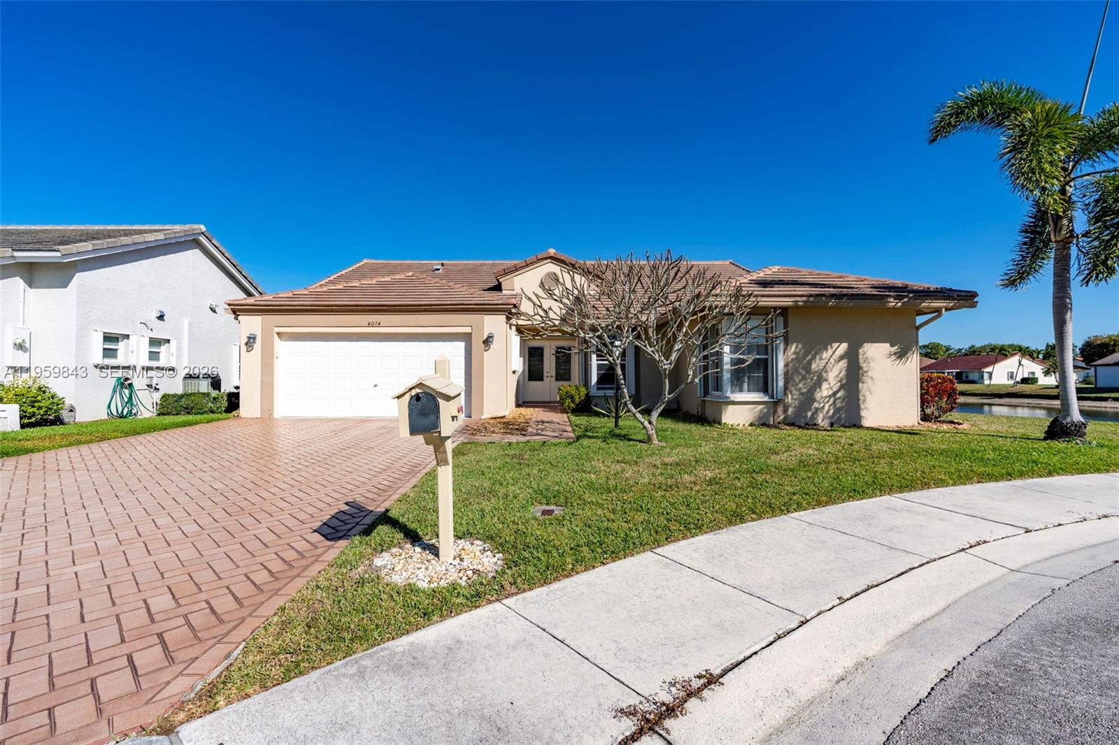 A single-story house with a tiled roof, paved driveway, and a mailbox in the front yard — 4024 Summer Chase Ct, Lake Worth FL 33467, LAKE WORTH, FL