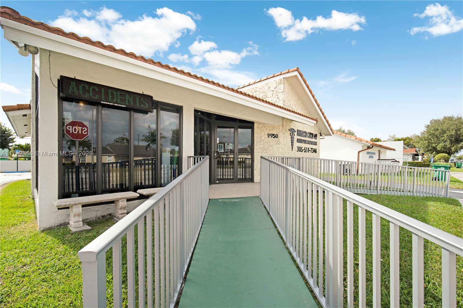 A single-story commercial building features a green wheelchair ramp leading to the glass entrance — 9950 SW 40th St, Miami FL 33165, MIAMI, FL