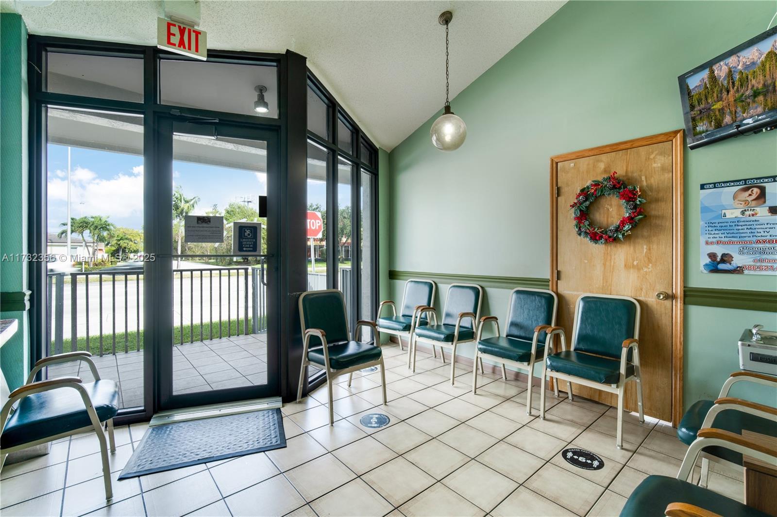 A waiting room features green walls, tiled floors, several chairs, and a glass entrance door — 9950 SW 40th St, Miami FL 33165, MIAMI, FL