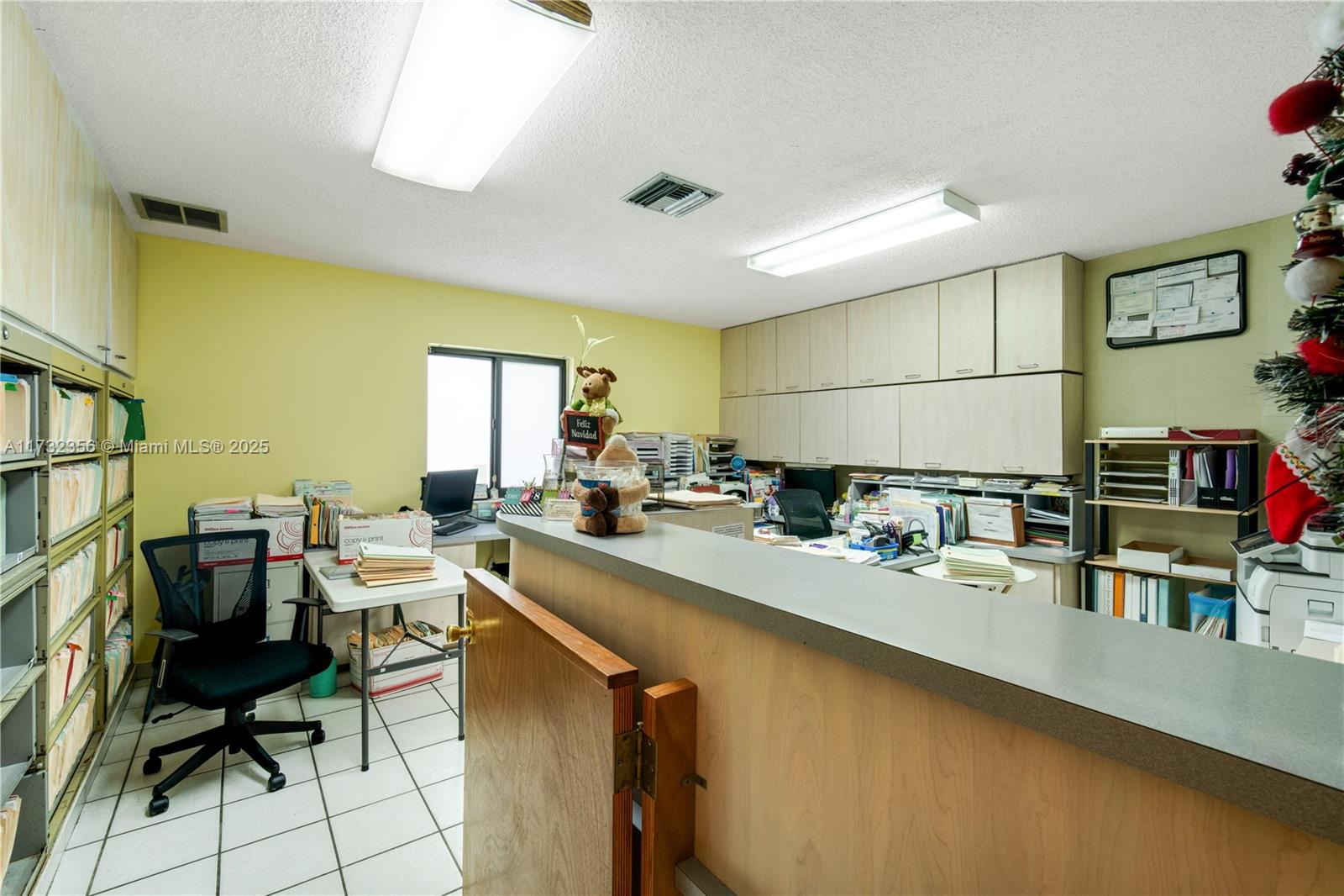 An office space features a reception counter, wall-mounted cabinets, filing shelves, and a desk — 9950 SW 40th St, Miami FL 33165, MIAMI, FL