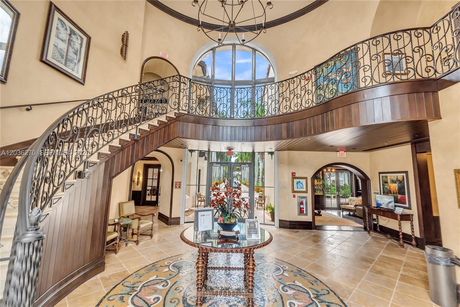 A grand foyer features a curved staircase with ornate iron railings and a tiled floor — 2925 NW 126th Ave # 1, Sunrise FL 33323, SUNRISE, FL
