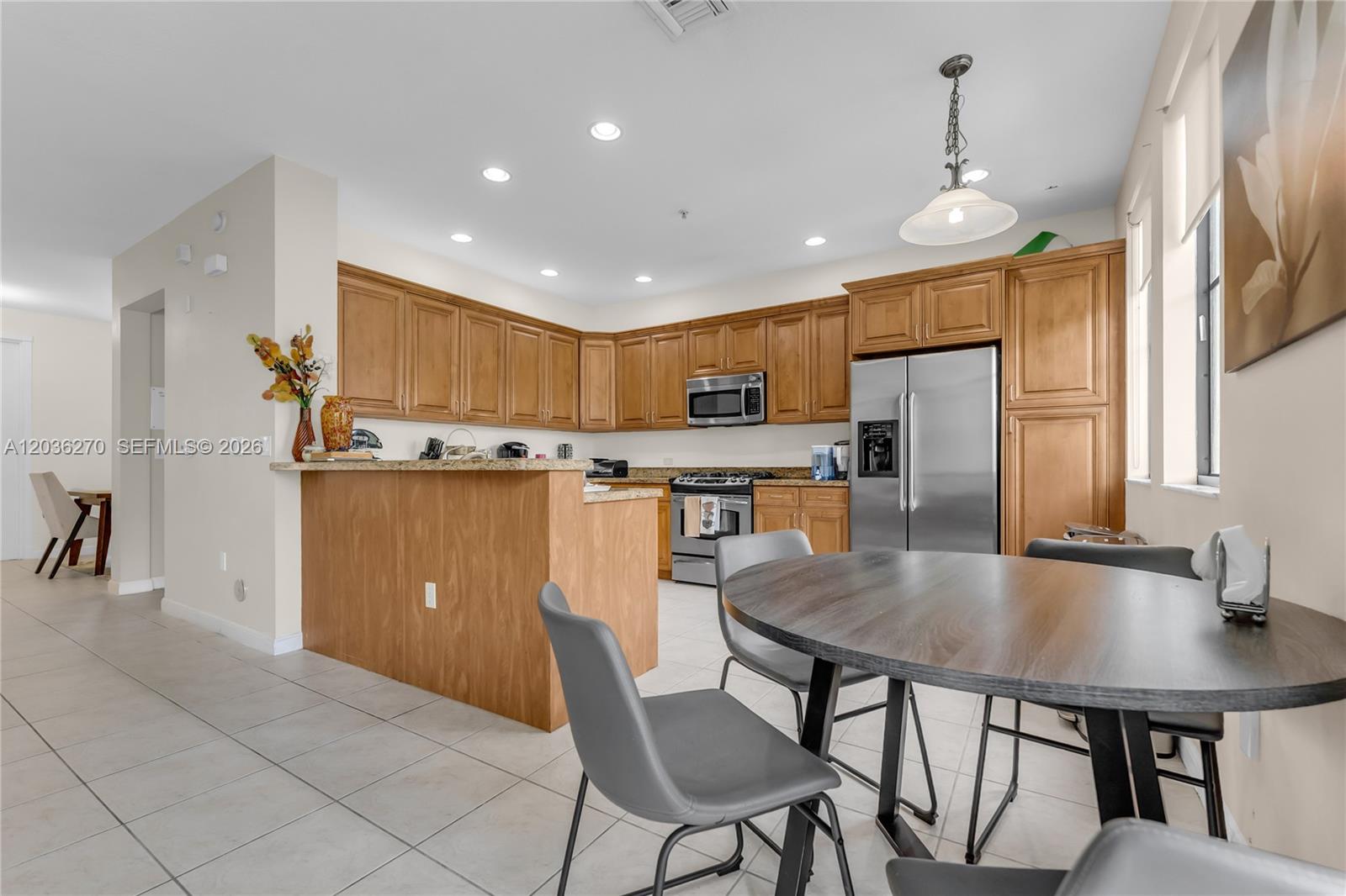 A kitchen features wood cabinets, stainless steel appliances, a breakfast bar, and a dining area — 2925 NW 126th Ave # 1, Sunrise FL 33323, SUNRISE, FL