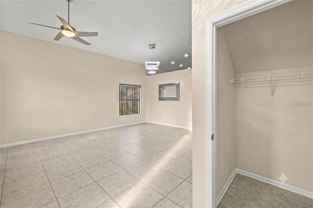 A room with light tile flooring, a ceiling fan, and an open closet — 5438 SW 49TH AVENUE, OCALA, FL