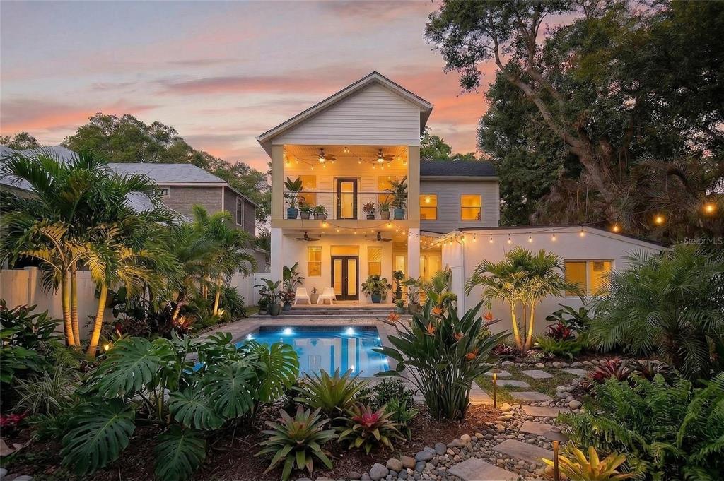 A two-story house with a pool, tropical landscaping, and a covered balcony at sunset — 2935 HELEN AVENUE, ORLANDO, FL