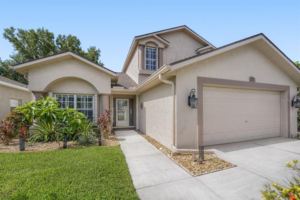 A two-story stucco house with a two-car garage and a front walkway — 11330 TEE TIME CIRCLE, NEW PORT RICHEY, FL
