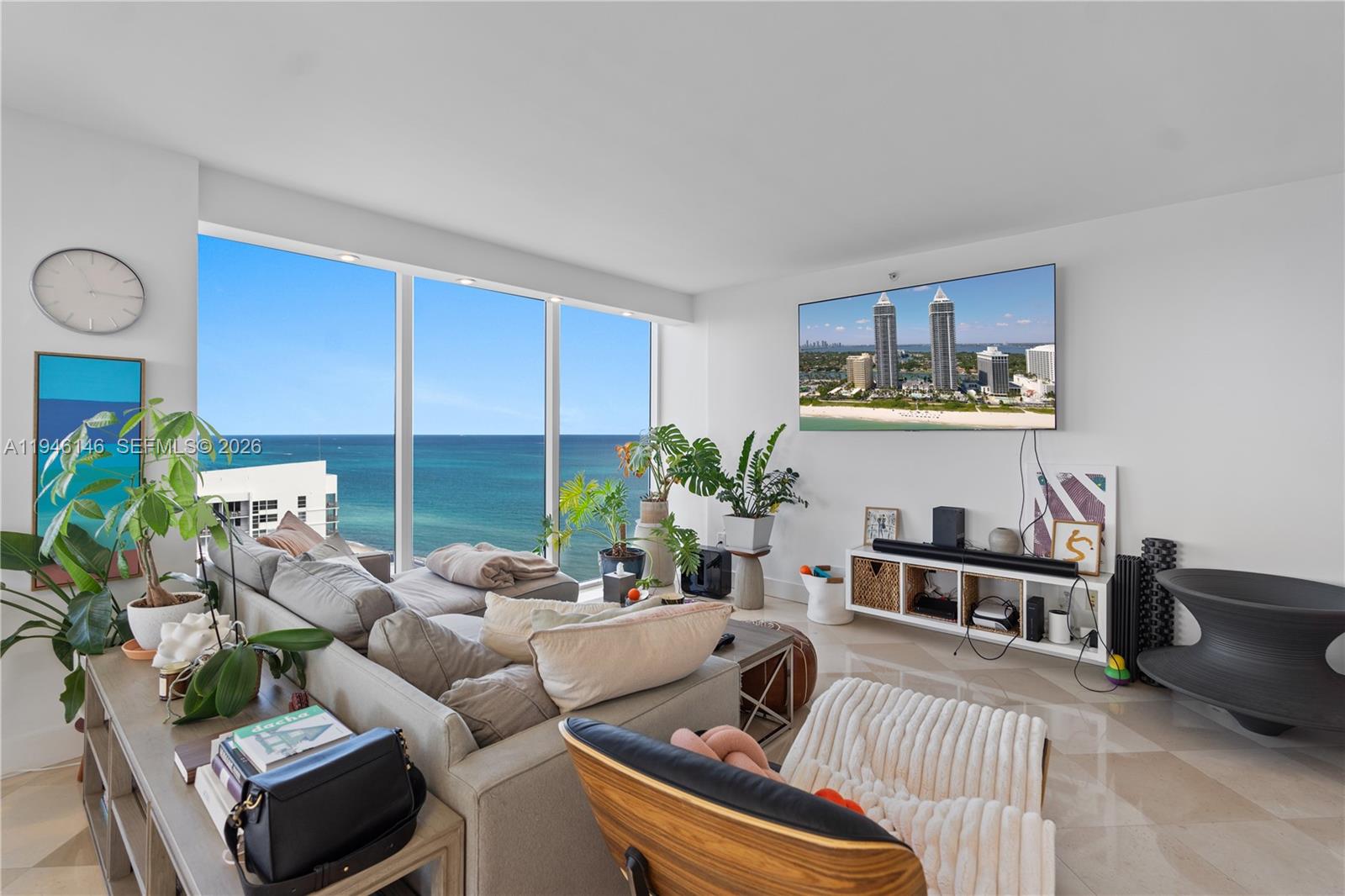 A living room features a large sectional sofa, a wall-mounted television, and floor-to-ceiling ocean views — 4779 Collins Ave # 2607, Miami Beach FL 33140, MIAMI BEACH, FL
