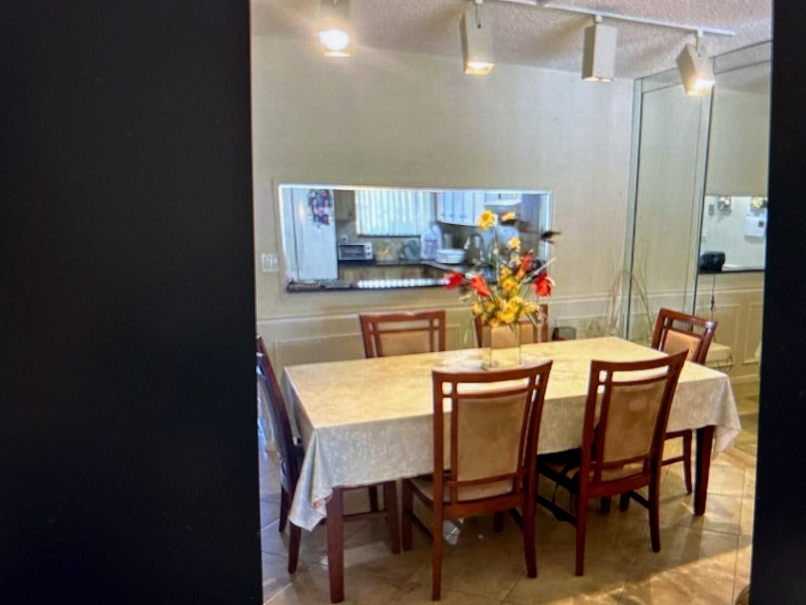A dining room with a table, six chairs, and a pass-through window to the kitchen — 3212 Strawflower Way # 206, FL 33467, FL