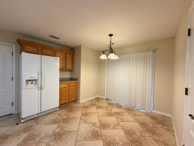 A kitchen dining area features tile flooring, a white refrigerator, and a hanging light fixture — 36022 MICHIGAN DRIVE, EUSTIS, FL
