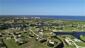 An aerial view shows a residential neighborhood with houses, winding roads, and several small lakes — 24183 SAVORY LANE, PUNTA GORDA, FL
