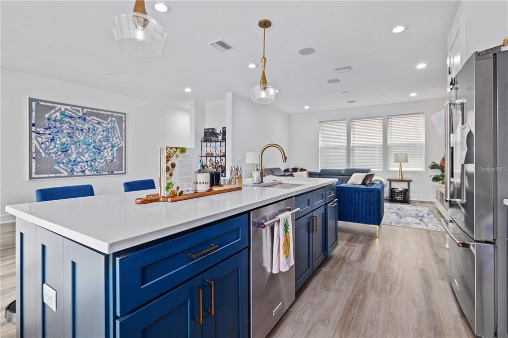 A kitchen island with blue cabinets and white countertops sits in an open-concept living space — 41 29TH STREET N, ST PETERSBURG, FL