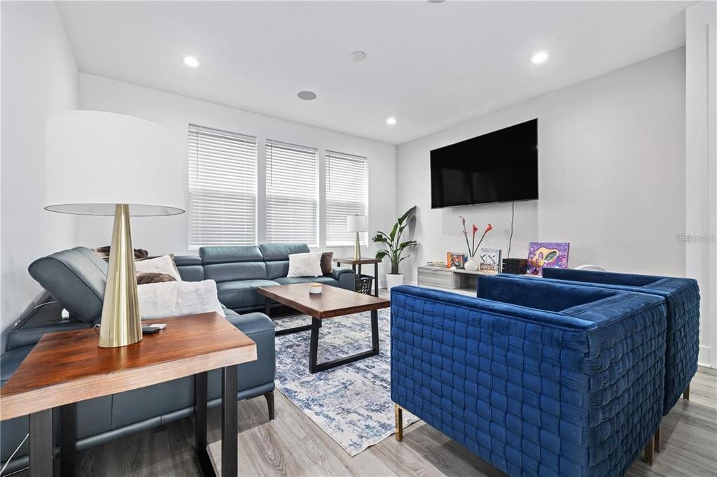 A living room features blue leather and velvet seating, a wooden coffee table, and television — 41 29TH STREET N, ST PETERSBURG, FL